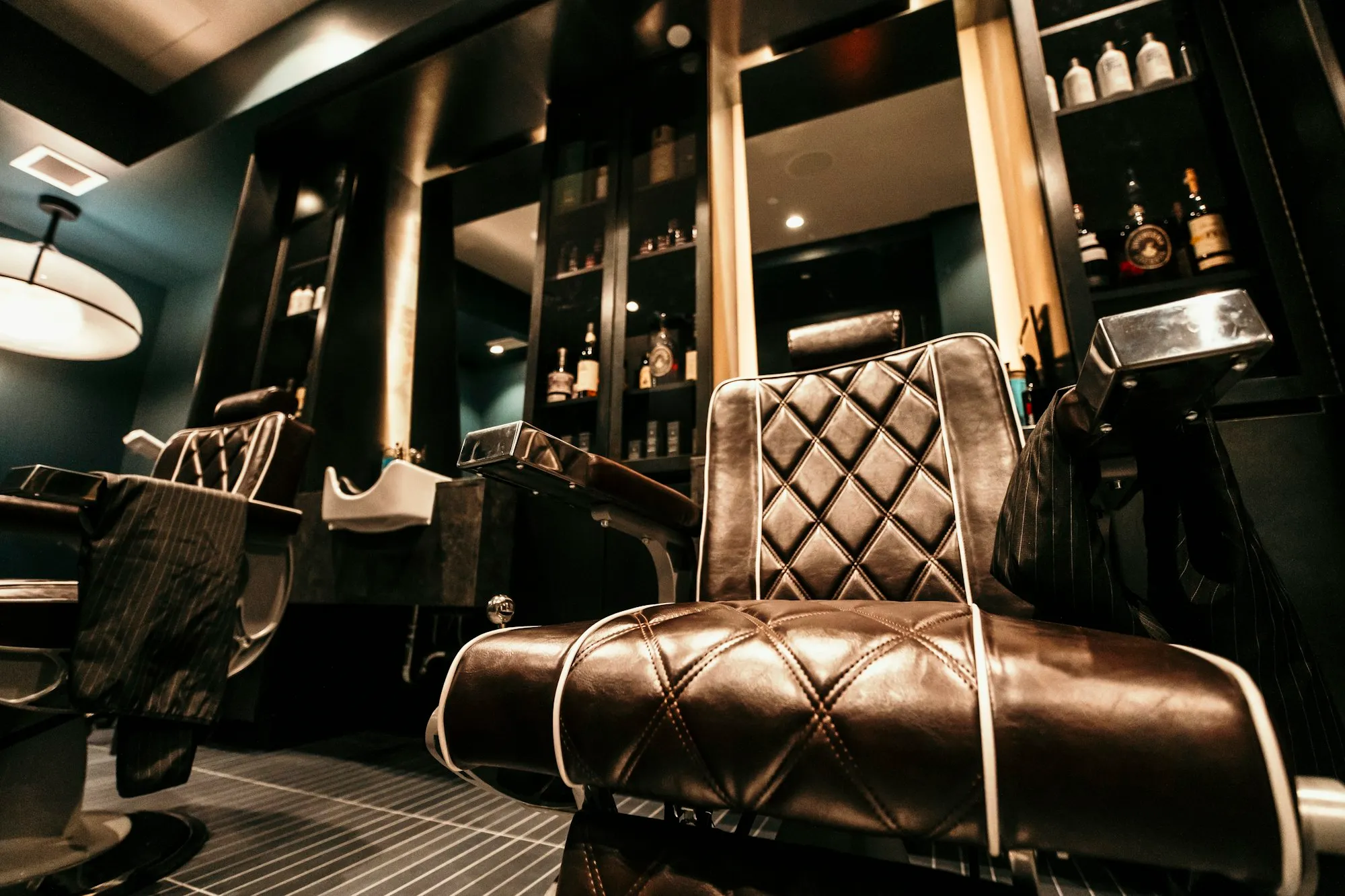 Empty barbershop with a leather chair in front of a mirror