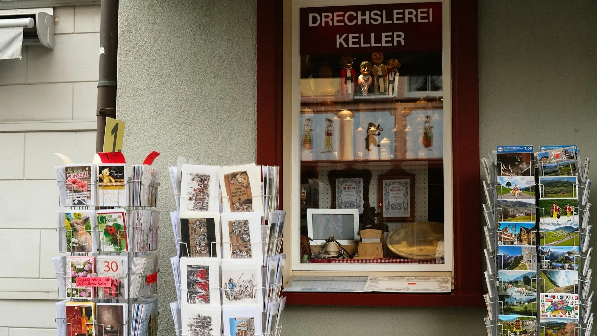 Shop window of a small woodturner in Appenzell with postcard stands