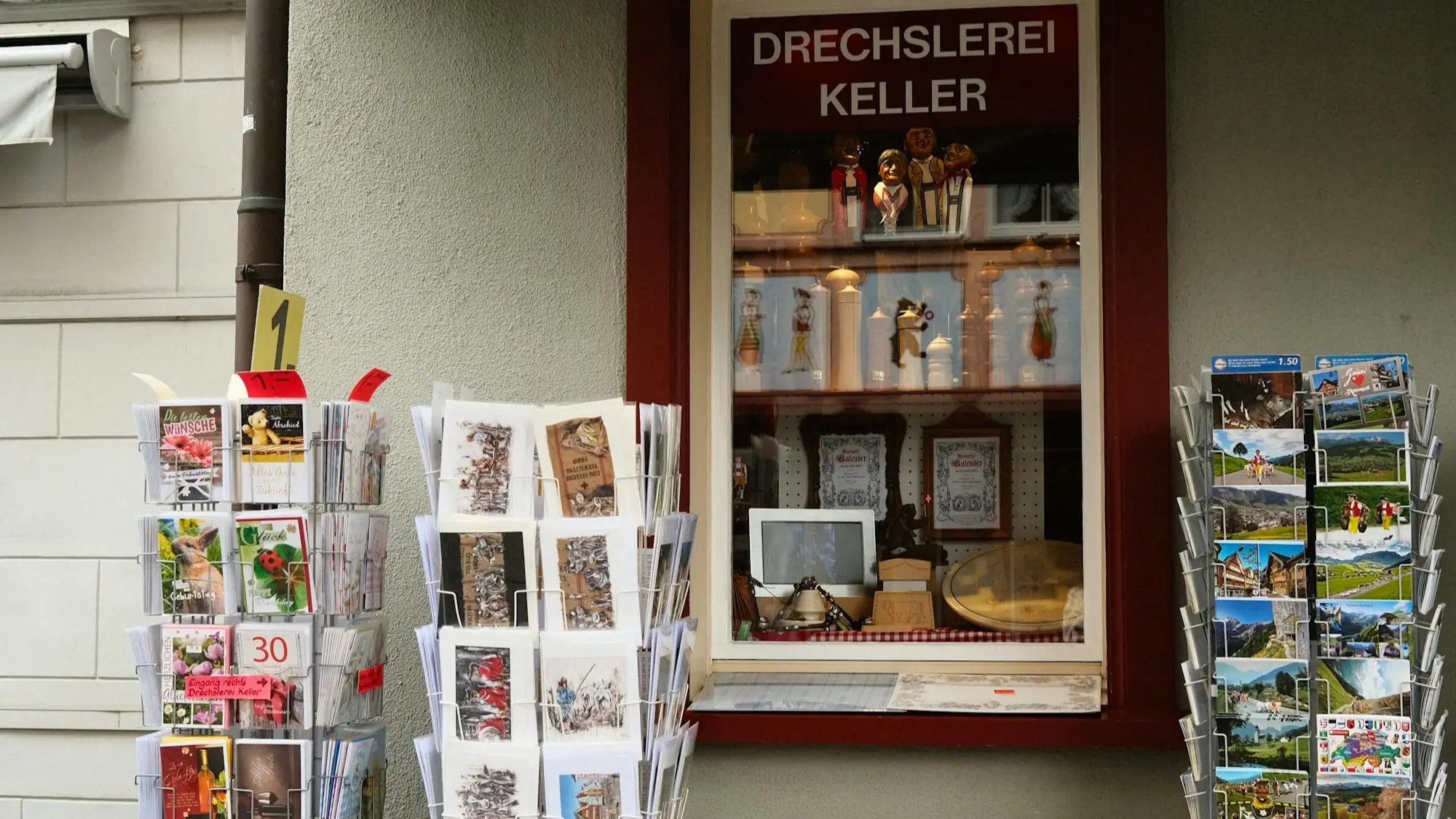Shop window of a small woodturner in Appenzell with postcard stands