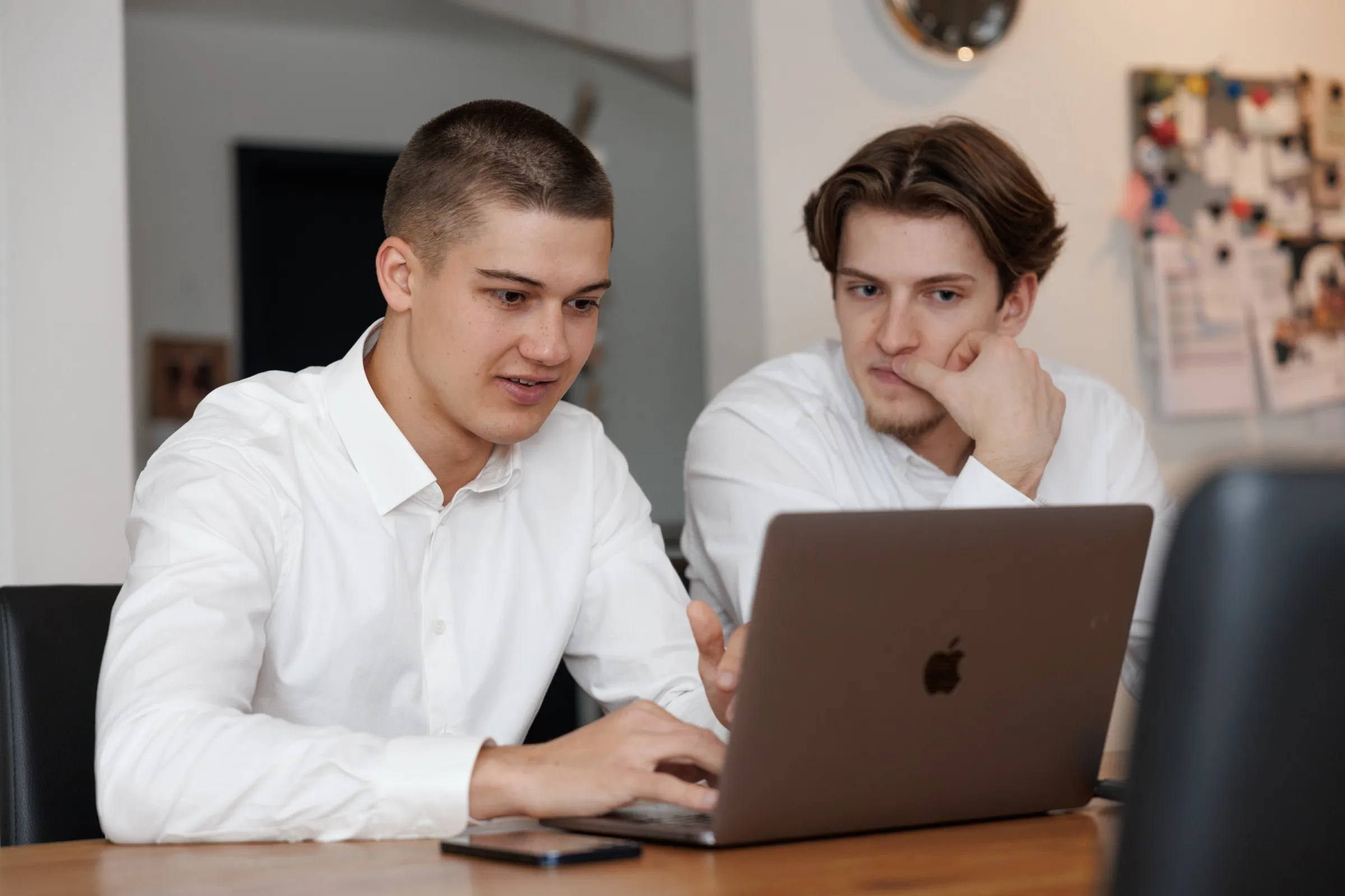Ramon Peter und Bastian Strohschein arbeiten gemeinsam an einem Laptop