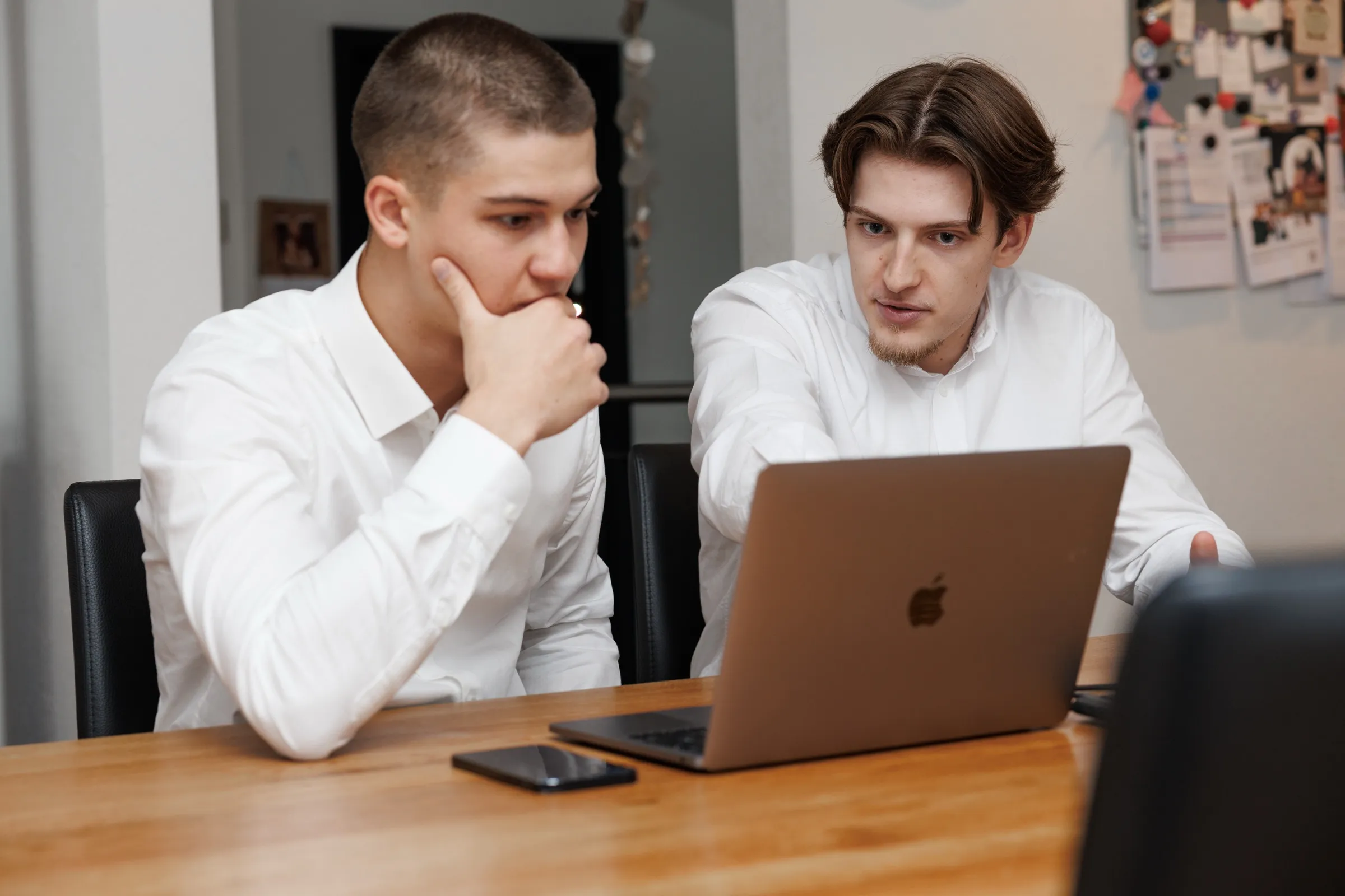 Ramon Peter arbeitet am Laptop, Bastian Strohschein schaut nachdenklich zu